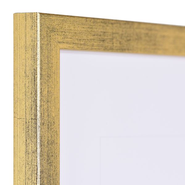 Vista de la esquina de un marco de fotos dorado estrecho con estructura de madera visible y superficie lisa